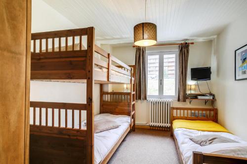 - une chambre avec 2 lits superposés et une télévision dans l'établissement Résidence Les Armaillis - Appartement de charme 3 pièces 7 personnes à Tignes proche des commerces, du bowling, de la piscine et des pistes dans le quart MAE-2175, à Tignes