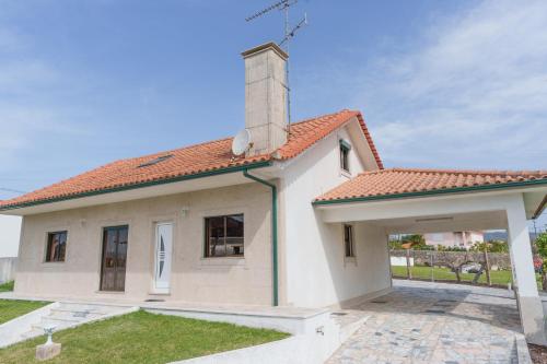 a small white house with a red roof at Vivenda do Calvario in Alvarães