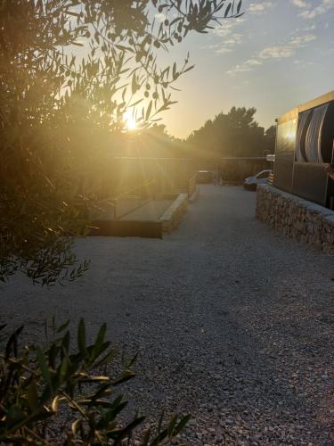 a sun is setting in the middle of a road at Mobile homes Laguna, beach Porat, Drage in Drage