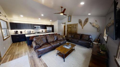 a living room with two leather couches and a table at Red River Retreat - WiFi - Hot Tub - Fireplace - Washer - Dryer - Grill in Red River