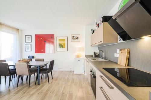 une cuisine et une salle à manger avec une table et des chaises dans l'établissement Résidence La Petite Ourse - maeva Home - Appartement 3 Pièces 8 Personnes - Confort MAE-3901, à Arâches-la-Frasse