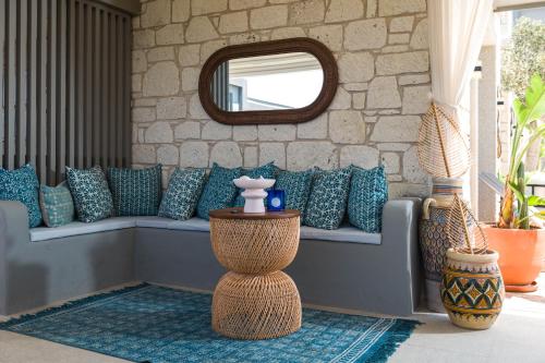 a living room with a couch with pillows and a mirror at Muse Alaçatı in Alacati
