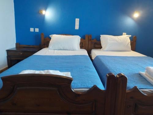 two beds in a bedroom with blue walls at Ilios Kalamaki in Kalamaki Heraklion