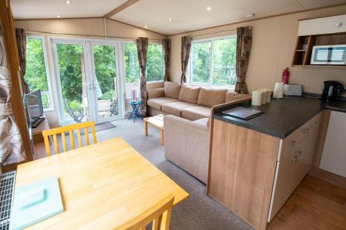 a caravan kitchen and living room with a couch at No 27 Coghurst Hall Hastings in Fairlight