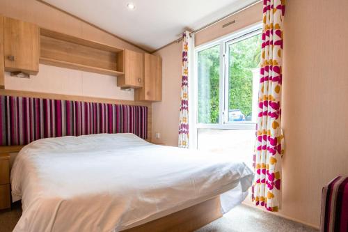 a bedroom with a large bed and a window at No 27 Coghurst Hall Hastings in Fairlight