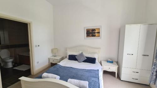 una camera da letto bianca con un letto con cuscini blu di 3 Central Bedroom flat a Cambridge