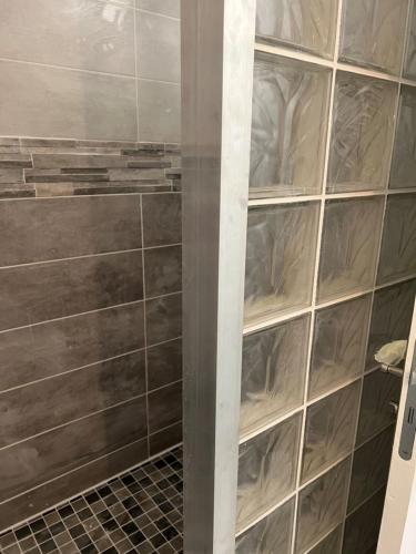 une unité d'étagères en verre dans une pièce avec un mur dans l'établissement MAS CLEMENTINE GÎTES Appartements, à Chambonas