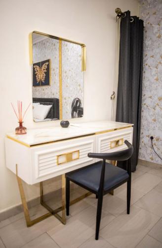 a bathroom with a vanity with a mirror and a chair at LEKKI SECRET MANSION 'n' SWIMMING POOl in Aja