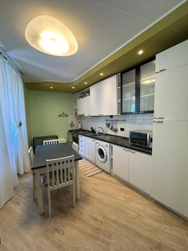 a kitchen with white cabinets and a table in it at Appartamento San Giorgio in Monzone