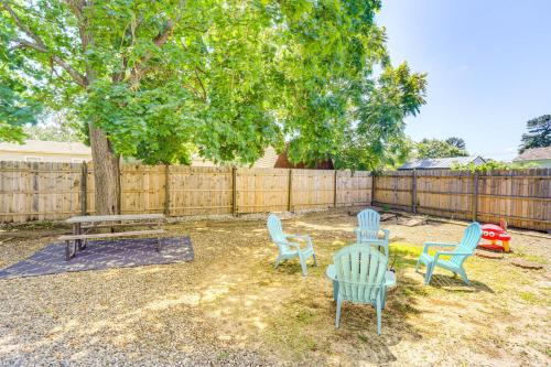 three chairs and a table in a yard with a fence at Bayville Getaway with Fire Pit - 2 Mi to Beach! in Bayville