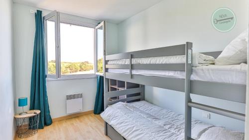 een slaapkamer met twee stapelbedden en een raam bij La Goelette 30 in Saint-Hilaire-de-Riez