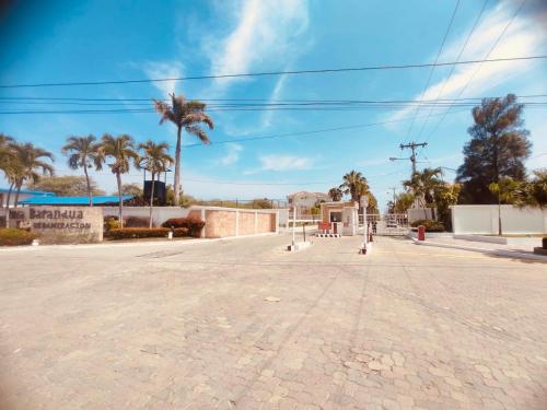 an empty street with palm trees and a blue sky at Casa en Punta Barandua Playa Privada in Santa Elena