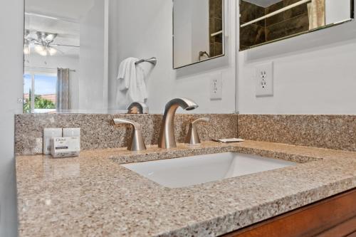 Un mostrador de baño con un lavabo y un espejo. en St. Augustine Ocean Racquet Club Unit 3303, en St. Augustine