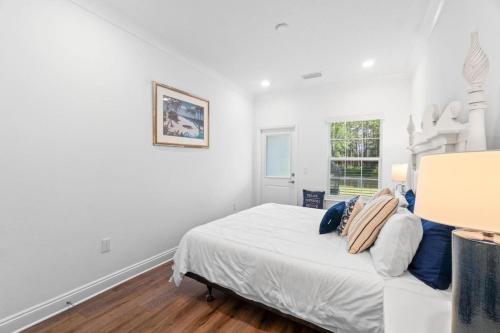 Un dormitorio blanco con una cama y una ventana. en Fountain View at Kara Lake Townhomes, en Santa Rosa Beach