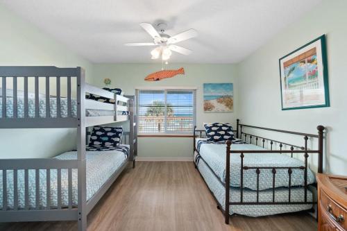a bedroom with two bunk beds and a ceiling fan at Beachside Bliss in Saint Augustine