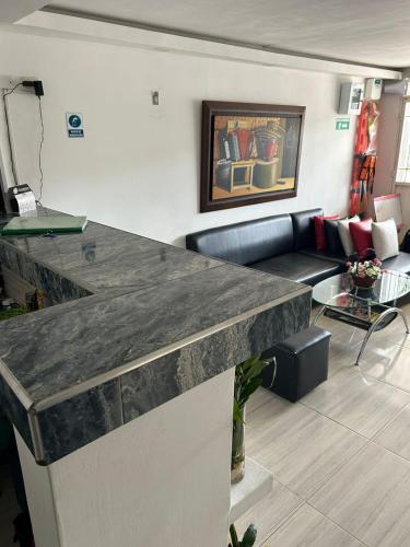 a living room with a couch and a counter top at Hotel Encanto Vallenato in Valledupar