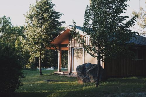 a small cabin with a rock in front of it at Pakaso sodyba in Kirdeikiai