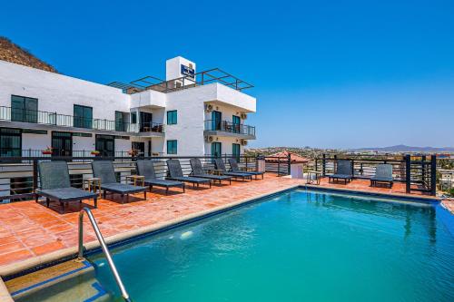 Una piscina con sillas y un edificio. en Princess 805 at Morgan Residences, en Cabo San Lucas
