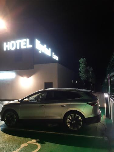 a car parked in front of a hotel at night at Kyriad Limoges - Ester in Limoges