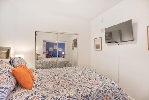 a bedroom with a bed and a large mirror at 1BR ROOFTOP POOL-10 MIN WALK TO BEACH in Boynton Beach