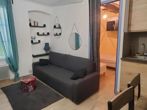 - un canapé noir dans le salon avec un miroir dans l'établissement Location de vacances, à Bandol