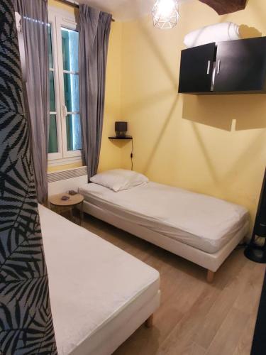 deux lits dans une chambre avec une fenêtre dans l'établissement Location de vacances, à Bandol