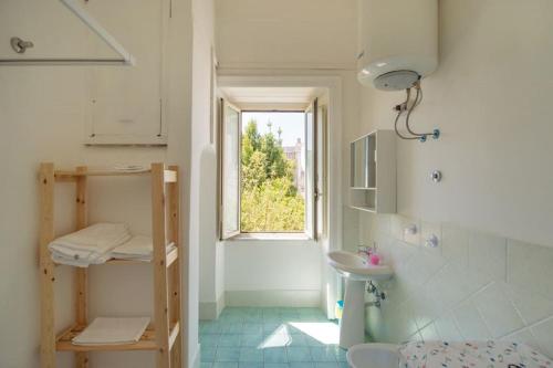 Un baño con lavabo y ventana. en Casa Elsa, en Procida