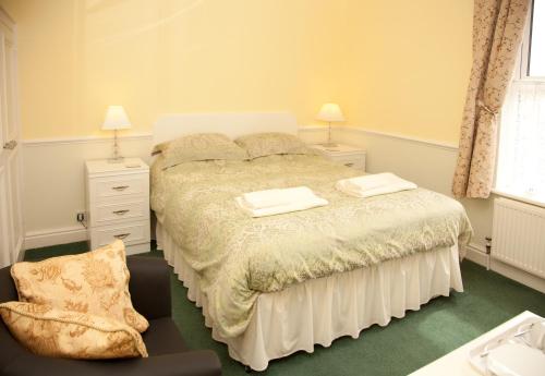 a bedroom with a bed with two towels on it at Binton Guest House in Filey