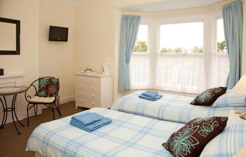 法利的住宿－Binton Guest House，一间卧室设有两张床和窗户。