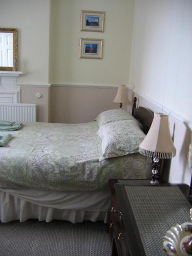 a bedroom with a bed and a table with two lamps at Binton Guest House in Filey