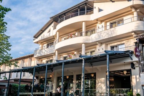 an apartment building with a balcony on a street at Hotel THR Center in Curtea de Argeş