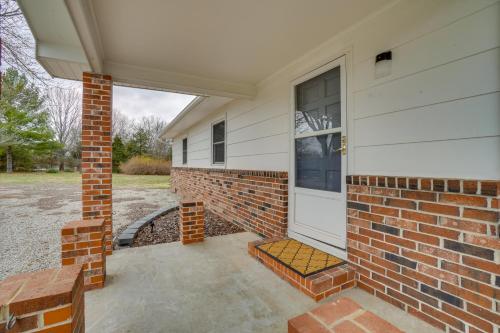 a front door of a house with a brick wall at Shell Knob Home with Fire Pit, Near Table Rock Lake! in Shell Knob