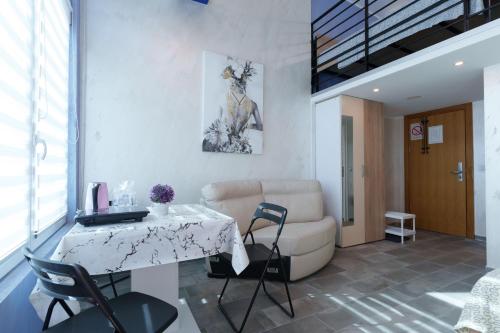 a living room with a table and a couch at Step rooms apt spa in Belgrade