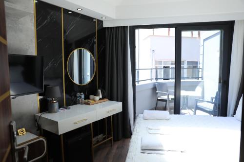 イスタンブールにあるMadrigal Boutıque Hotelの白いベッドと鏡のある寝室