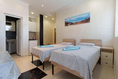 a bedroom with two beds and a kitchen at Step rooms apt spa in Belgrade