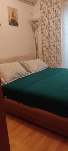 a bed with a green mattress in a room at Una apartmani Petrovac in Petrovac na Moru