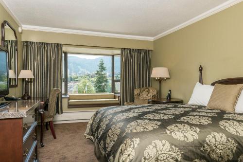 a hotel room with a bed and a window at Crest Hotel in Prince Rupert