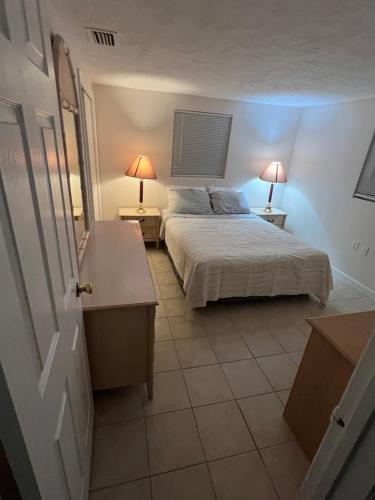 a bedroom with a bed and two lamps on two tables at Small Cozy Home in Beverly Hills
