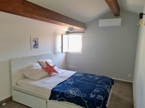une chambre avec un lit avec une couette bleue et blanche dans l'établissement Appartement T3 Duplex sous les Toits de Marseille Panier Vieux Port, à Marseille