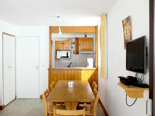 une cuisine et une salle à manger avec une table en bois dans l'établissement Résidence Tommeuses - Appartement fonctionnel·Pieds des pistes ·Balcon MAE-3654, à Tignes