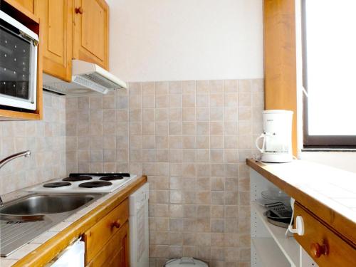 une cuisine avec un évier et une cuisinière dans l'établissement Résidence Tommeuses - Appartement fonctionnel·Pieds des pistes ·Balcon MAE-3654, à Tignes