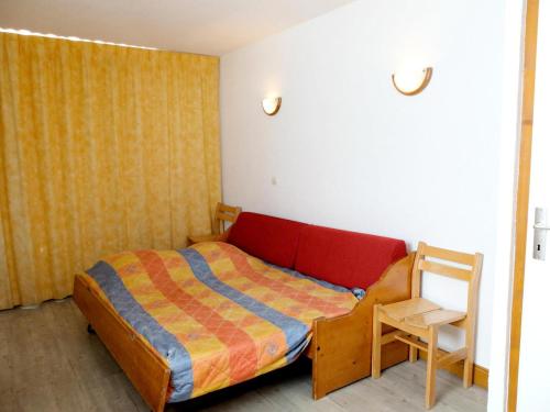 une petite chambre avec un lit et une chaise dans l'établissement Résidence Tommeuses - Appartement fonctionnel·Pieds des pistes ·Balcon MAE-3654, à Tignes