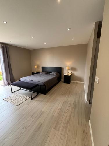 - une grande chambre avec un lit et du parquet dans l'établissement Maison tout confort à proximité des plages, à Villeneuve-Loubet