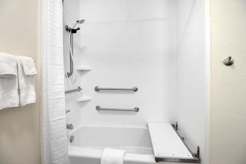 a white bathroom with a shower and a toilet at Candlewood Suites Waco by IHG in Waco