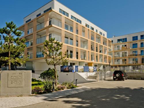 a large building with a car parked in front of it at Casa Baia BlueApart Hel in Hel