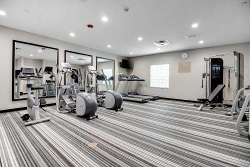 a gym with treadmills and ellipticals and mirrors at Candlewood Suites Waco by IHG in Waco