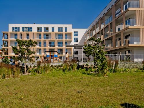 a large apartment building with a lawn in front of it at Casa Baia BlueApart Hel in Hel