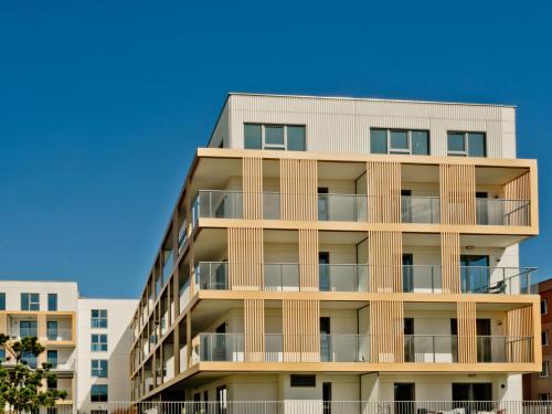 an apartment building with balconies and a blue sky at Casa Baia BlueApart Hel in Hel