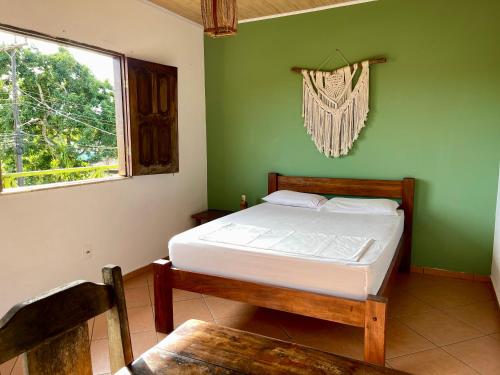 a bedroom with a bed in a green wall at Guava Hostel Serra Grande in Uruçuca