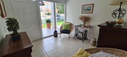 a living room with a chair and a table and a door at Ananda Troia in Troia